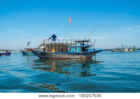 Hoi An, Vietnam - August 15, 2015: Vietnamese fishing boats on the Vin Cura Dai river, the mouth of the Thu Bon river near Hoi An in Vietnam.