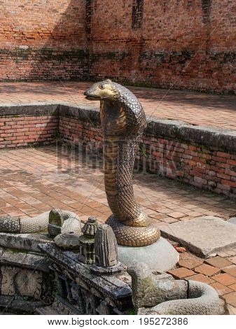KATHMANDU, BHAKTAPUR, NEPAL. 30 September 2008: The Naga Pokhari (Snake Pond) in The Palace of fifty five Windows in Bhaktapur's Durbar Square is a royal water tank encircled by a writhing stone cobra.