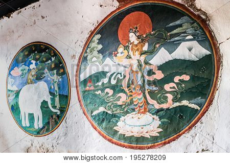Trongsa Bhutan - September 12 2016: Ancient murals at the Trongsa Dzong Trongsa Bhutan. Beautiful paintings of woman and elephant on the wall.