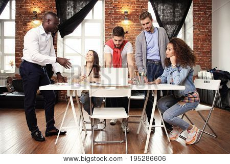 Teamwork concept.Young creative coworkers working with new startup project in modern office.Group of people analyze data on desktop computer.