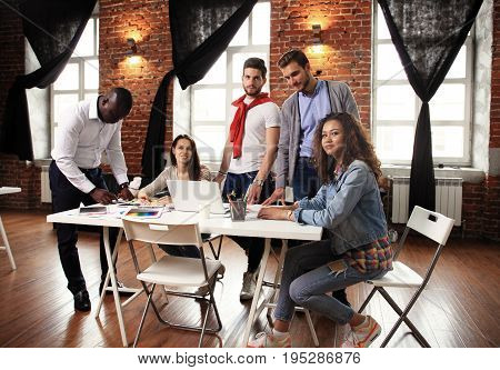 Teamwork concept.Young creative coworkers working with new startup project in modern office.Group of people analyze data on desktop computer.