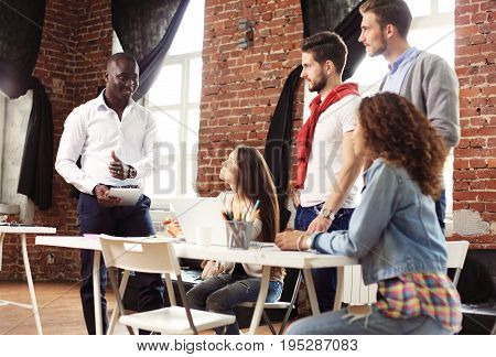 Teamwork concept.Young creative coworkers working with new startup project in modern office.Group of people analyze data on desktop computer.