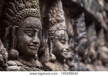 The half-stone statue face of Apsara stuck on the wall.