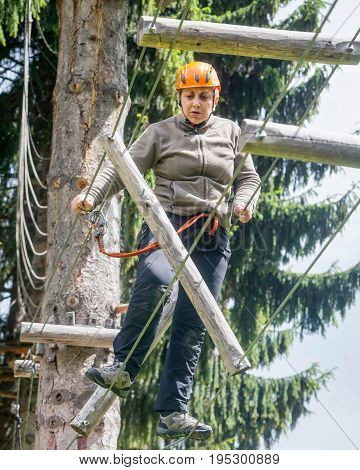 Tense Romanian Tourist Woman Enjoying Climbing Activity In Retezat Mountains Adventure Park On A Summer Day