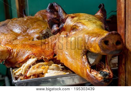 Delicious hornado roasted pork, over a silver tray, ecuadorian traditional typical andean food located in the municipal market in San Francisco in the city of Quito.