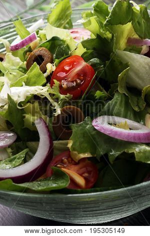 Bowl Of Salad With Vegetables And Greens On Wooden Table