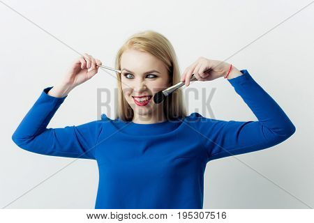 Girl Squinting Eyes On Silly Face With Makeup Brushes