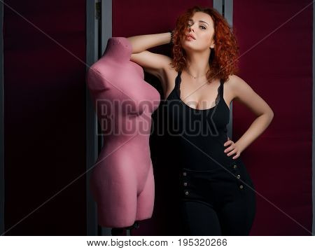 Women standing next pink pinktailor's dummy on the red screen