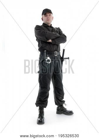 Security man wearing black uniform equipped with police club and handcuffs standing confidently, shot on white