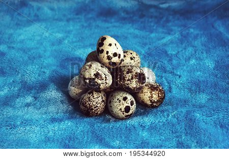 Pile Of Quail Eggs Against Blue Background