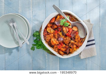 Baked chicken breast with vegetables on blue wooden table top view. Dinner table concept