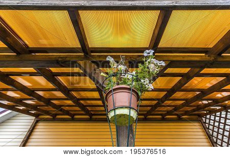 The roof of the veranda of orange polycarbonate on blue sky background.