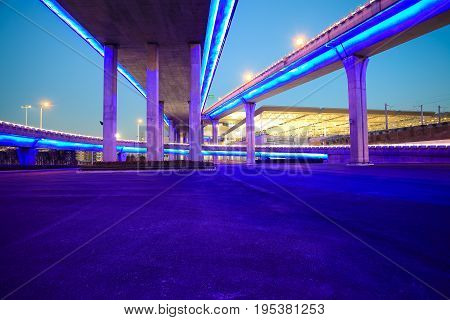 Empty Road Floor With City Viaduct Bridge Of Neon Lights Night
