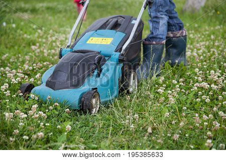 Closeup of grassmower moving on the grass