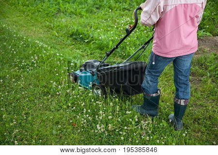Closeup of grassmower moving on the grass