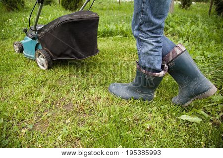 Closeup of grassmower moving on the grass