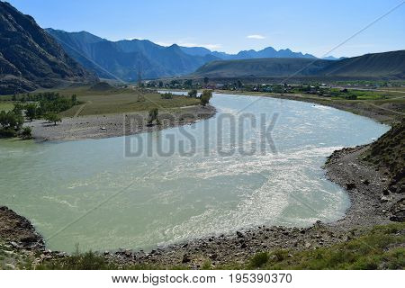 Katun river flows near village in Altai mountains. Altay Republic Siberia Russia.
