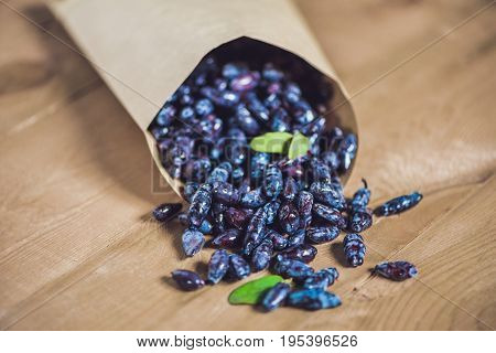 Fresh Honeysuckle Blue Berry Fruits With Leaf On A Wooden Background