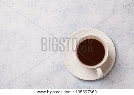 Black coffee in a white cup on a gray background