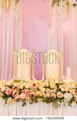 festive table for the bride and groom decorated with pink cloth and flowers. Wedding table decor concept.