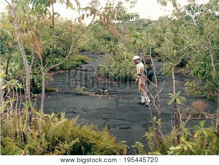 SAVAI'I / SAMOA - CIRCA 1990: An American tourist with a backpack explores a lava field.