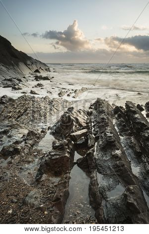 Beautiful Colorful Vibrant Sunset Over Rocky Beach With Long Exposure