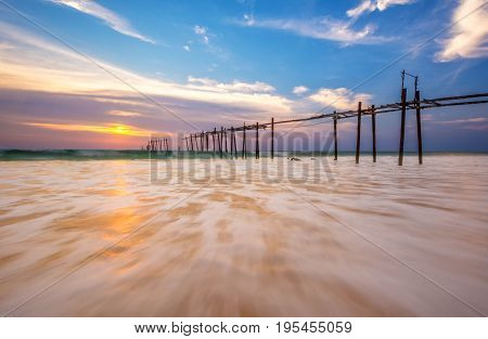 Evening light during sunset on the sea with an old wooden bridge.
