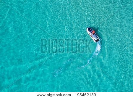 People are playing a jet ski in the sea.Aerial view. Top view.amazing nature background.The color of the water and beautifully bright. Fresh freedom. Adventure day.clear turquoise at tropical beach.