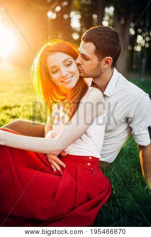 Love couple kissing in summer park on sunset