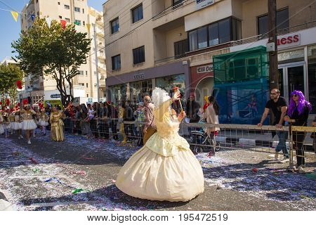 LIMASSOL, CYPRUS - FEBRUARY 26: Carnivalists in a silver cylinder hats joyfully follow the Limassol Municipality Band during the annual Carnival Parade, February 26, 2017 in Limassol.