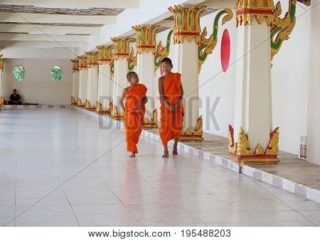 Sangkhlaburi Thailand- March 05 2017: Two Buddhist novice monks walking along the corridor of the temple in Sangkhlaburi District Kanchanaburi Province Thailand.