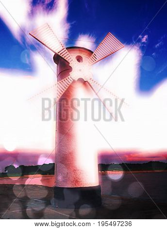 Film Effect. White Old Lighthouse Decorated As Windmill By Sea On Rocky Coast. Seascape And Landscap