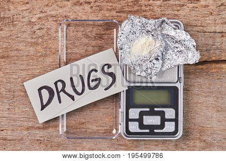 Concept of drugs business. Close up of drugs, digital scales, white powder, message.