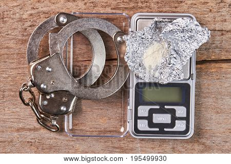 Handcuffs, digital scales, heroin close up. Punishment of narcotics dealers.