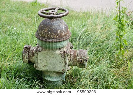 Old hydrant on a background of grass