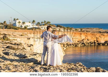 Romantic dating. Young loving couple walking together by the beach enjoying sea.