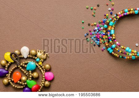 costume jewellery artistically scattered on brown background