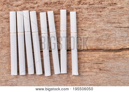 Set of tobacco cigarettes, wooden background. Several white tobacco cigarettes lying on wooden table.