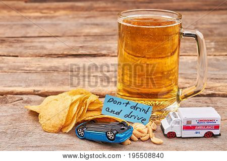 Glass of beer, turned over car, ambulance. Drink and drive dangerous for life.