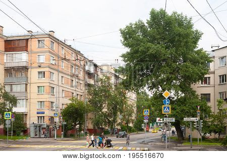 MOSCOW - JULY 13: Residential houses big tree and people on Shmitovski street on July 13 2017 in Moscow. Shmitovski Street is located in Central Administrative District of Moscow.