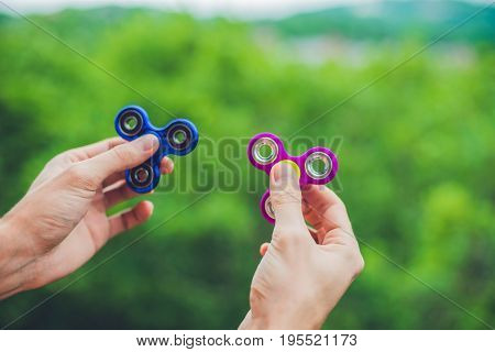 Close Up Of A Man's Hand Who Is Holding A Fidget Spinner In A Park