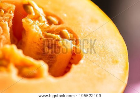 Half of ripe melon close up on blurred background.