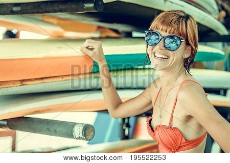 Young sexy girl in red swimsuit - surfer with surf board posing on the Nusa Dua beach, tropical Bali island. Family lifestyle, people water sport lessons and beach swimming activity on summer vacation.