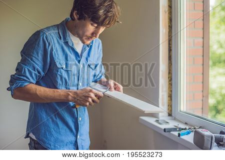 Man In A Blue Shirt Does Window Installation