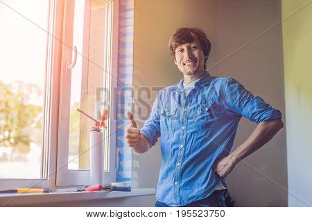 Man In A Blue Shirt Does Window Installation