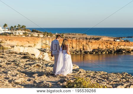Romantic dating. Young loving couple walking together by the beach enjoying sea.