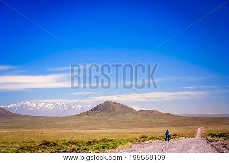 Woman cycling on the famous national Ruta 40  quarenta, in the remote part of central Argentina