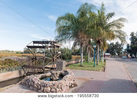 KEIMOES SOUTH AFRICA - JUNE 12 2017: A water wheel replica in an irrigation canal next to the main road in Keimoes in the Northern Cape Province