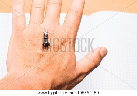The chess king lies on the back of the palm this figure symbolizes the success of this as in real life there are kings and there are less important persons who did not achieve such heights