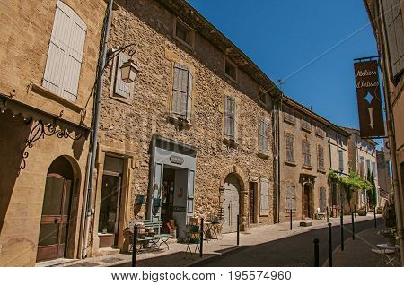 Lourmarin, France - July 07, 2016. View of quiet alley with stone buildings and shops in the center of the lovely Lourmarin. Located in the Vaucluse department, Provence region, southeastern France